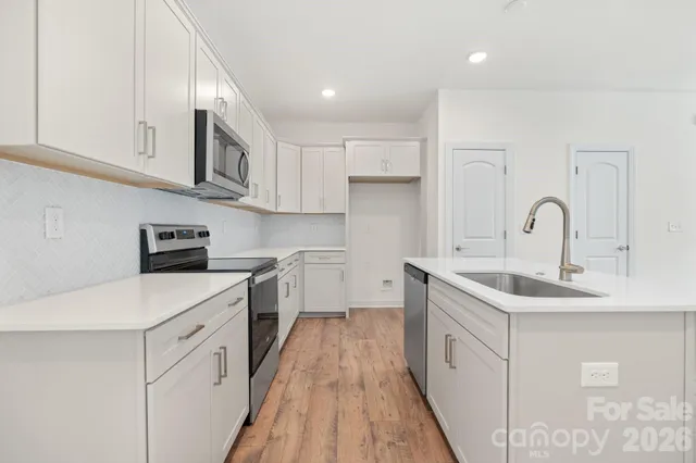 a kitchen with cabinets appliances a sink and a counter top space