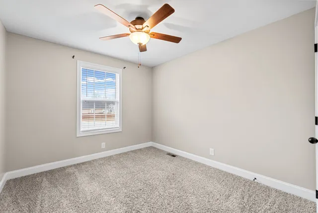 an empty room and chandelier fan