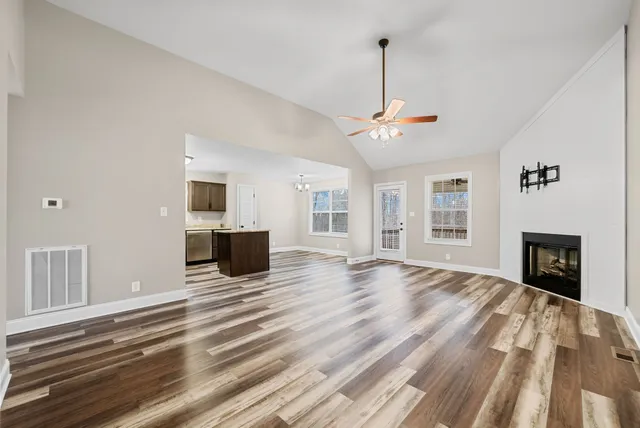 a view of a livingroom with wooden floor and a fireplace