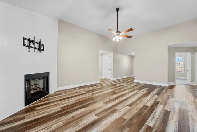 a view of an empty room with window and fireplace