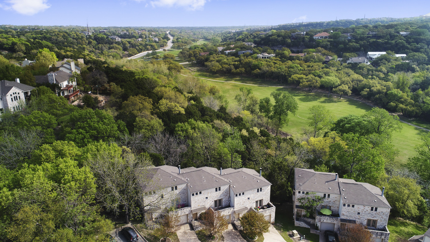 9201 Simmons Road, Unit 119 Austin, TX 78759 - Photo 1 of 22 Aerial perspective of suburban area with a tree filled landscape