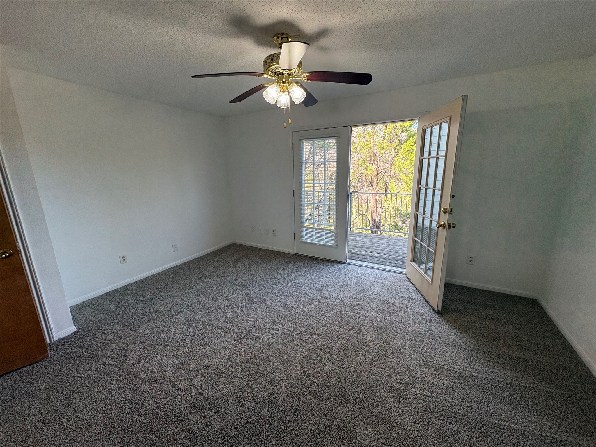 9201 Simmons Road, Unit 119 Austin, TX 78759 - Photo 21 of 22 Spare room featuring a textured ceiling, dark colored carpet, and ceiling fan