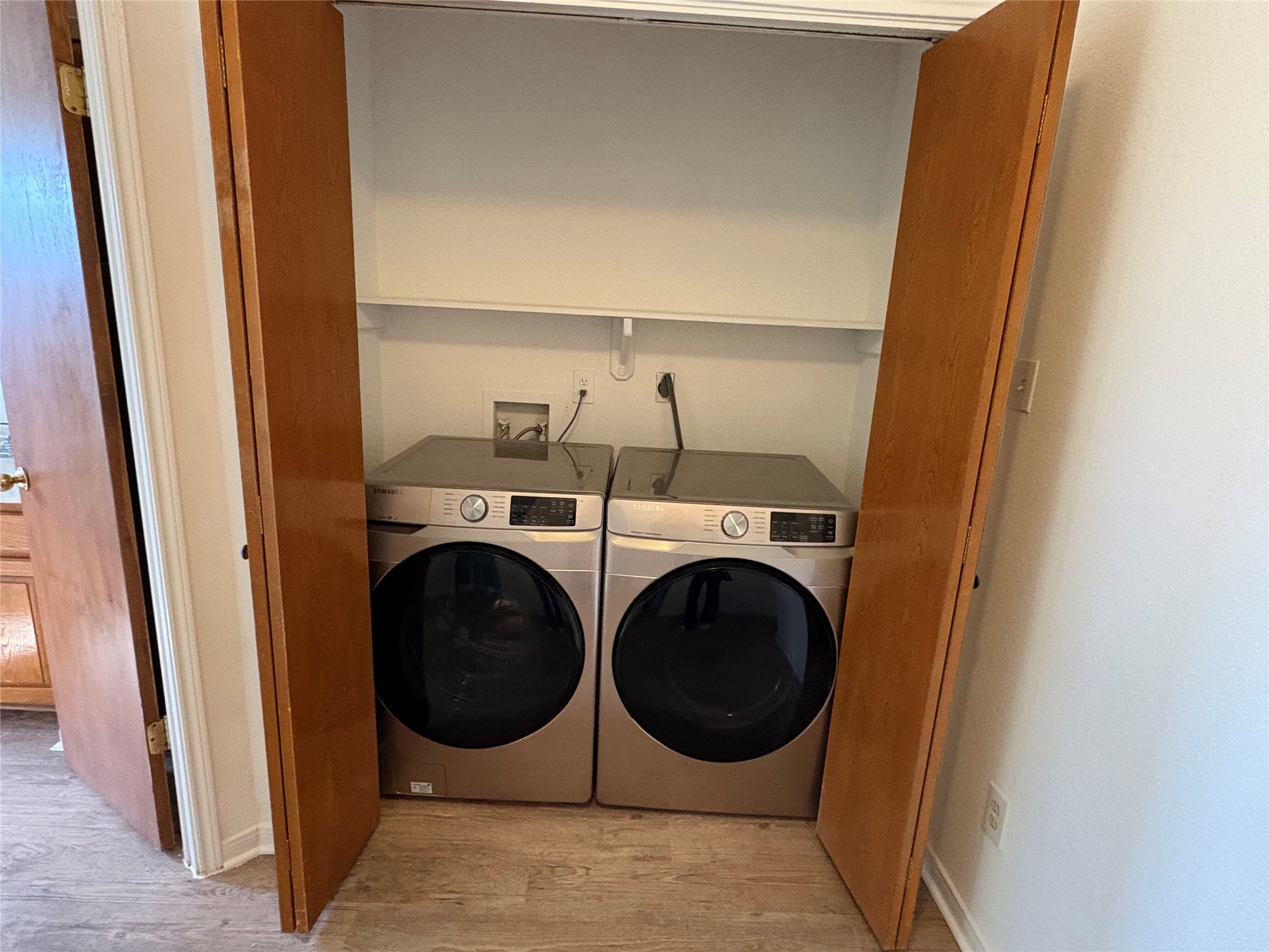 9201 Simmons Road, Unit 119 Austin, TX 78759 - Photo 10 of 22 Laundry area featuring wood finished floors and washing machine and dryer