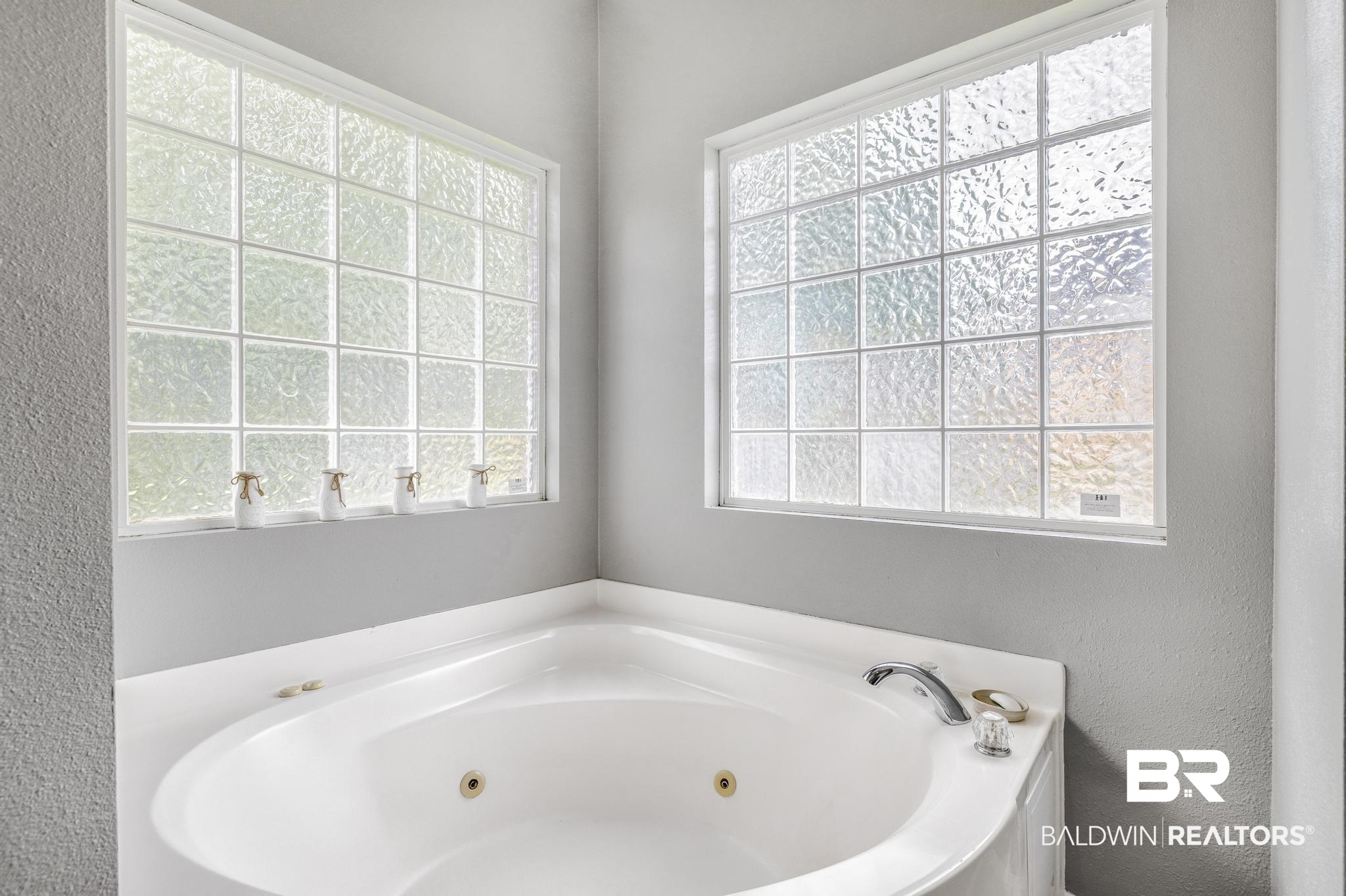 35814 Delvan Lane Bay Minette, AL 36507 - Photo 33 of 53 Corner soaking tub with integrated jets, surrounded by a white composite deck