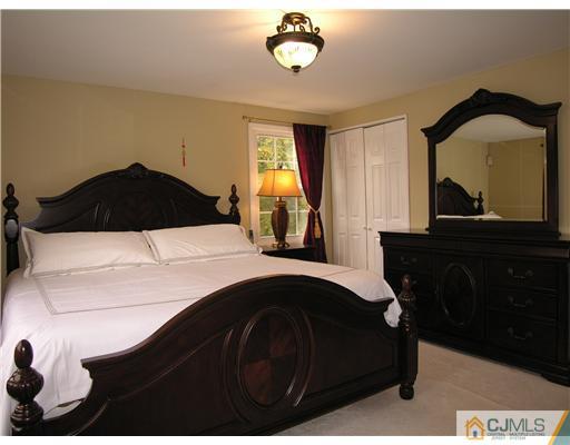 25 Tripplet Road Somerset, NJ 08873 - Photo 7 of 10 a bedroom with a bed and a closet with mirror