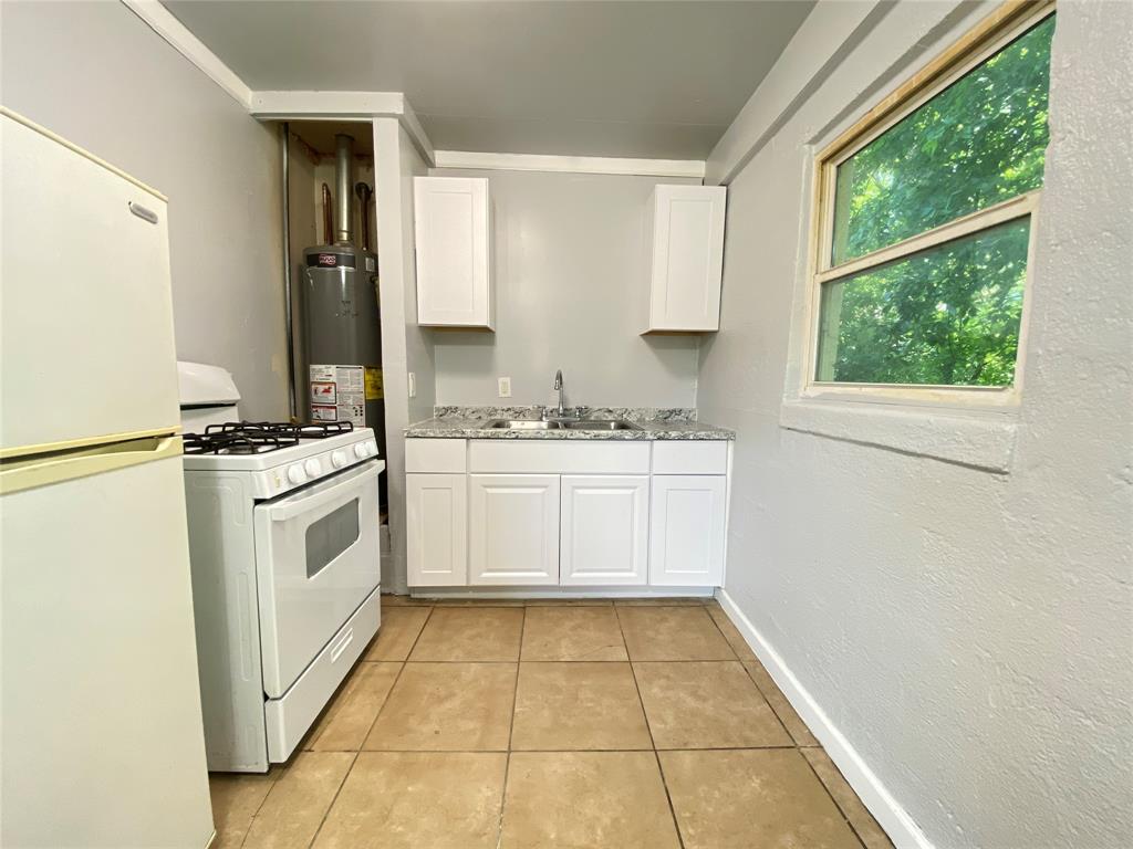 1203 Hall Street Lancaster, TX 75146 - Photo 9 of 11 a white cabinets a sink a counter top space and cabinets