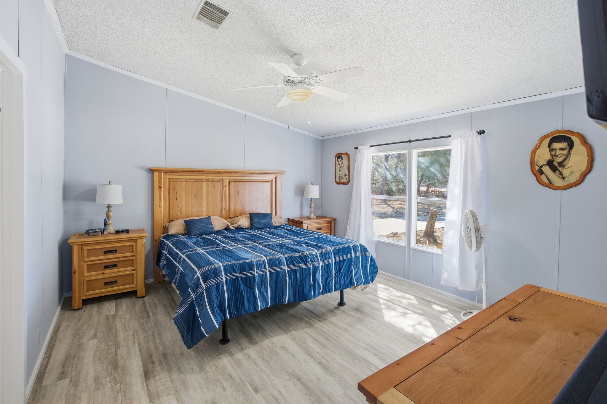 182 Wayside Court Elgin, TX 78621 - Photo 21 of 40 Bedroom with a decorative wall, crown molding, wood finished floors, and a ceiling fan