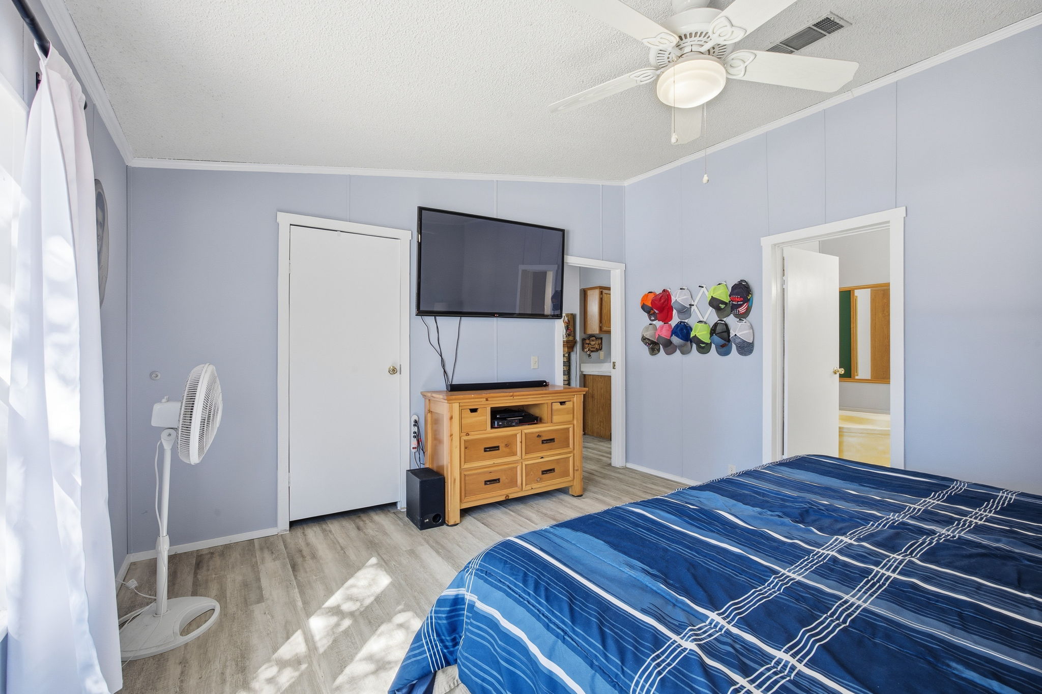 182 Wayside Court Elgin, TX 78621 - Photo 22 of 40 Bedroom with crown molding, a ceiling fan, light wood-style flooring, and connected bathroom