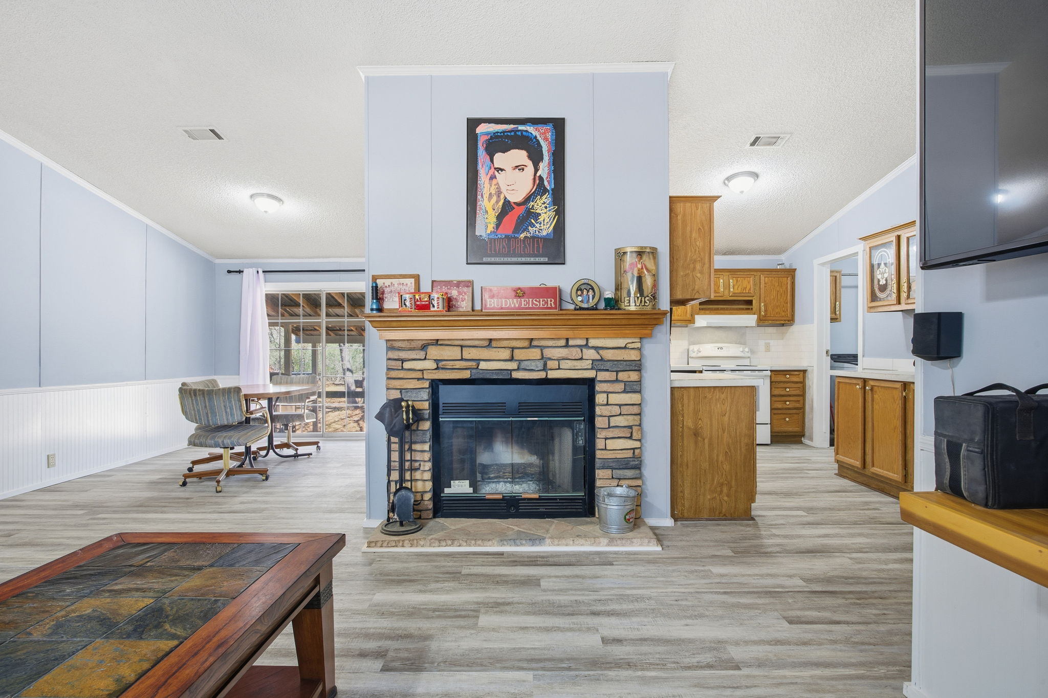 182 Wayside Court Elgin, TX 78621 - Photo 7 of 40 Living room featuring ornamental molding, light wood-style flooring, and a stone fireplace