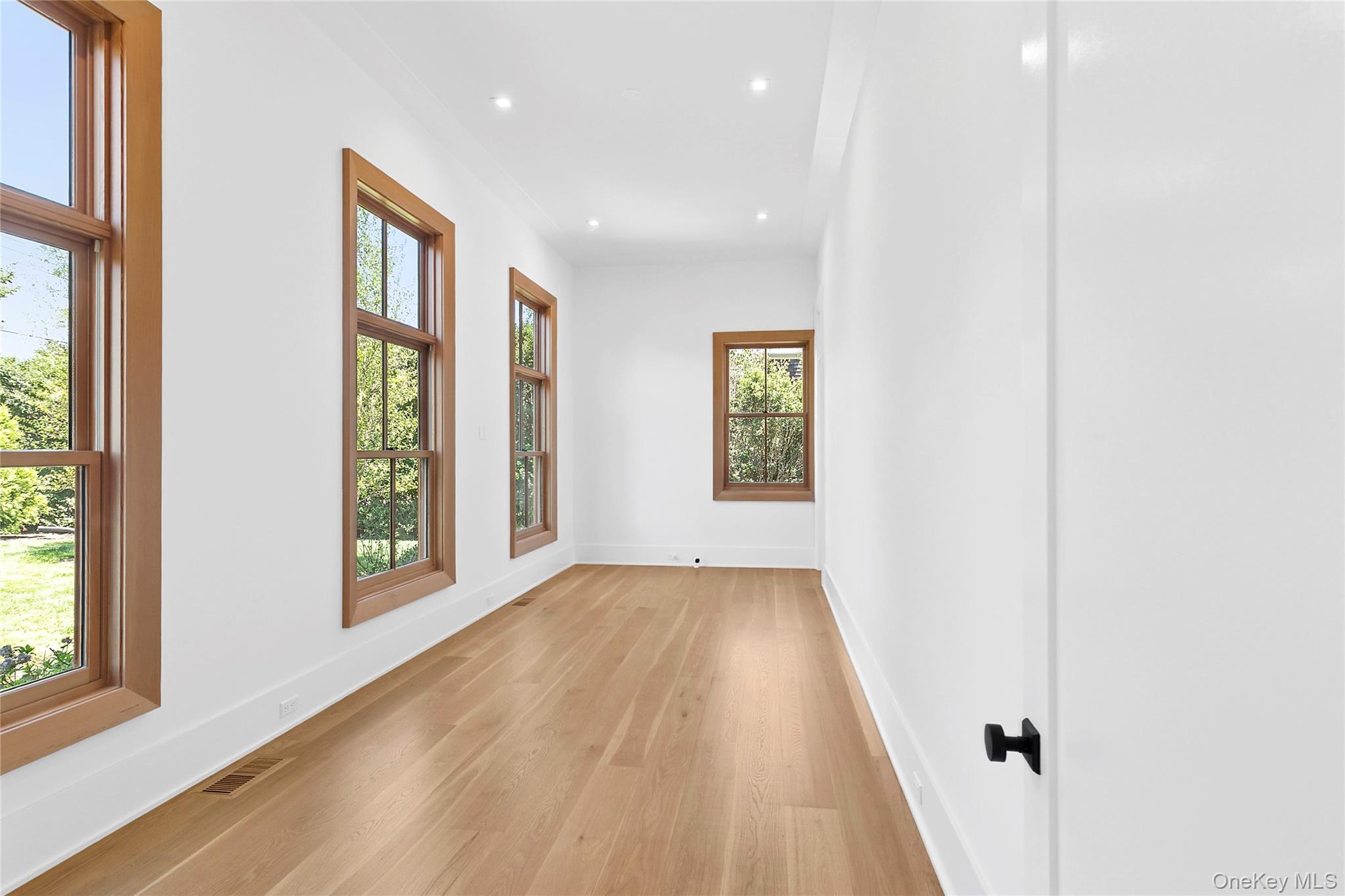 522 Wickapogue Road Southampton, NY 11968 - Photo 13 of 49 a view of an empty room with a window and wooden floor