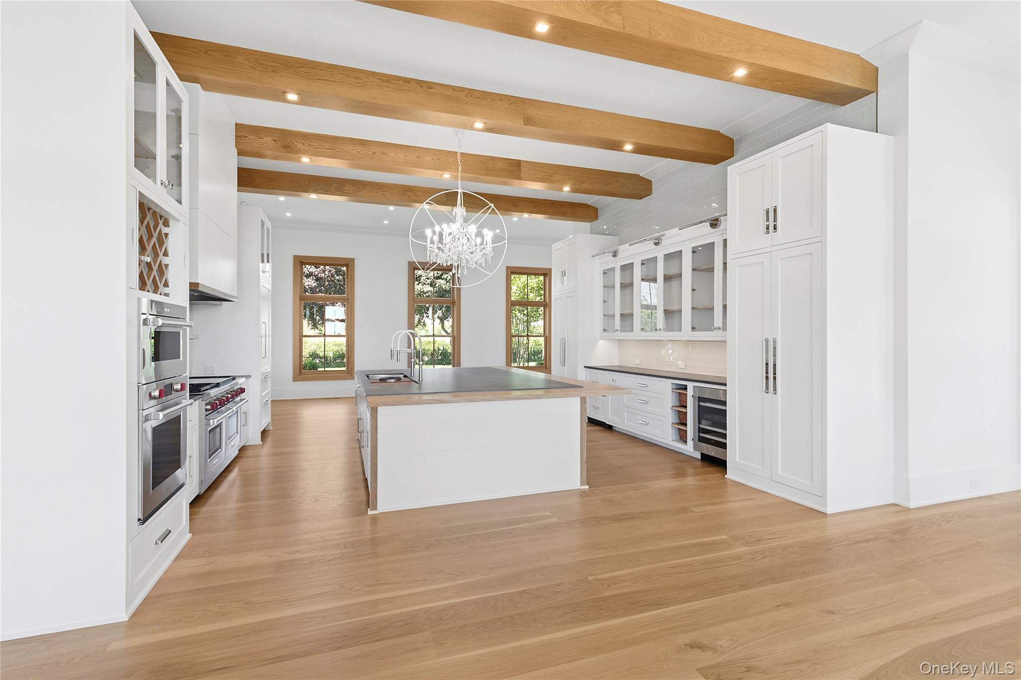 522 Wickapogue Road Southampton, NY 11968 - Photo 15 of 49 a large white kitchen with cabinets and wooden floor