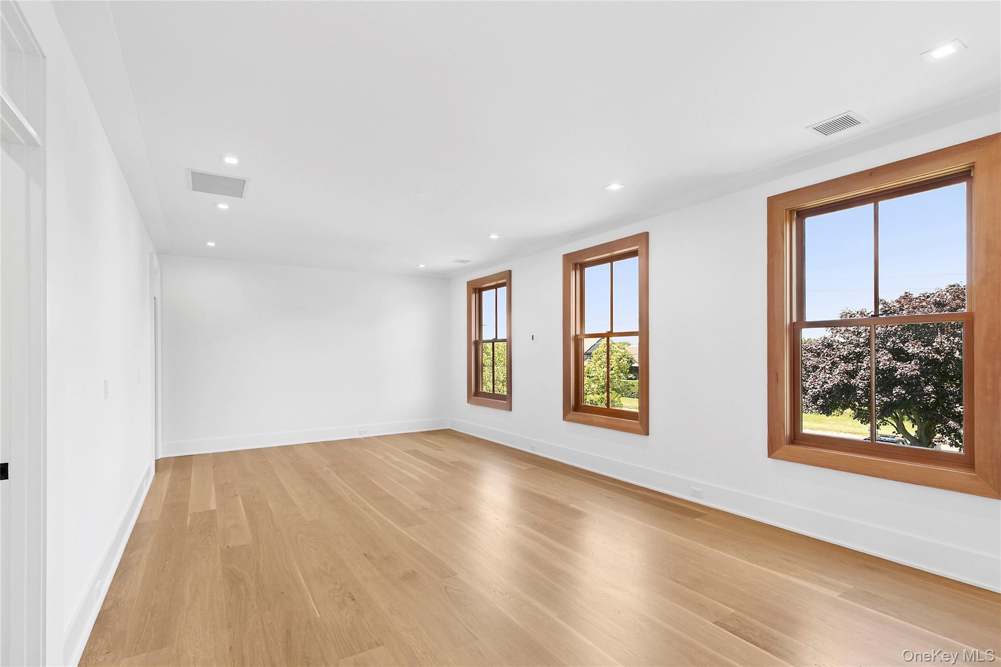 522 Wickapogue Road Southampton, NY 11968 - Photo 19 of 49 a view of an empty room with window and wooden floor