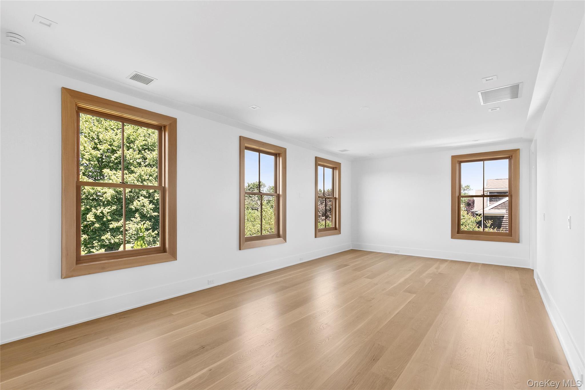 522 Wickapogue Road Southampton, NY 11968 - Photo 23 of 49 a view of an empty room with wooden floor and a window