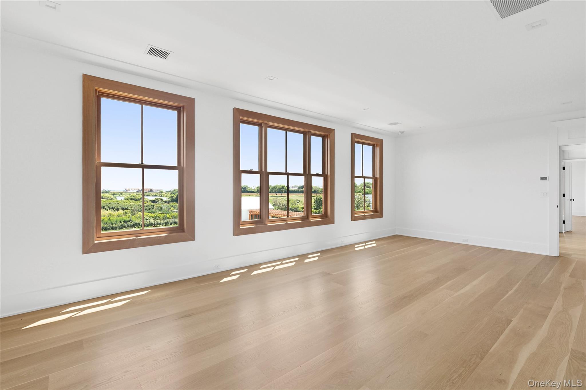 522 Wickapogue Road Southampton, NY 11968 - Photo 24 of 49 a view of an empty room with a window and wooden floor