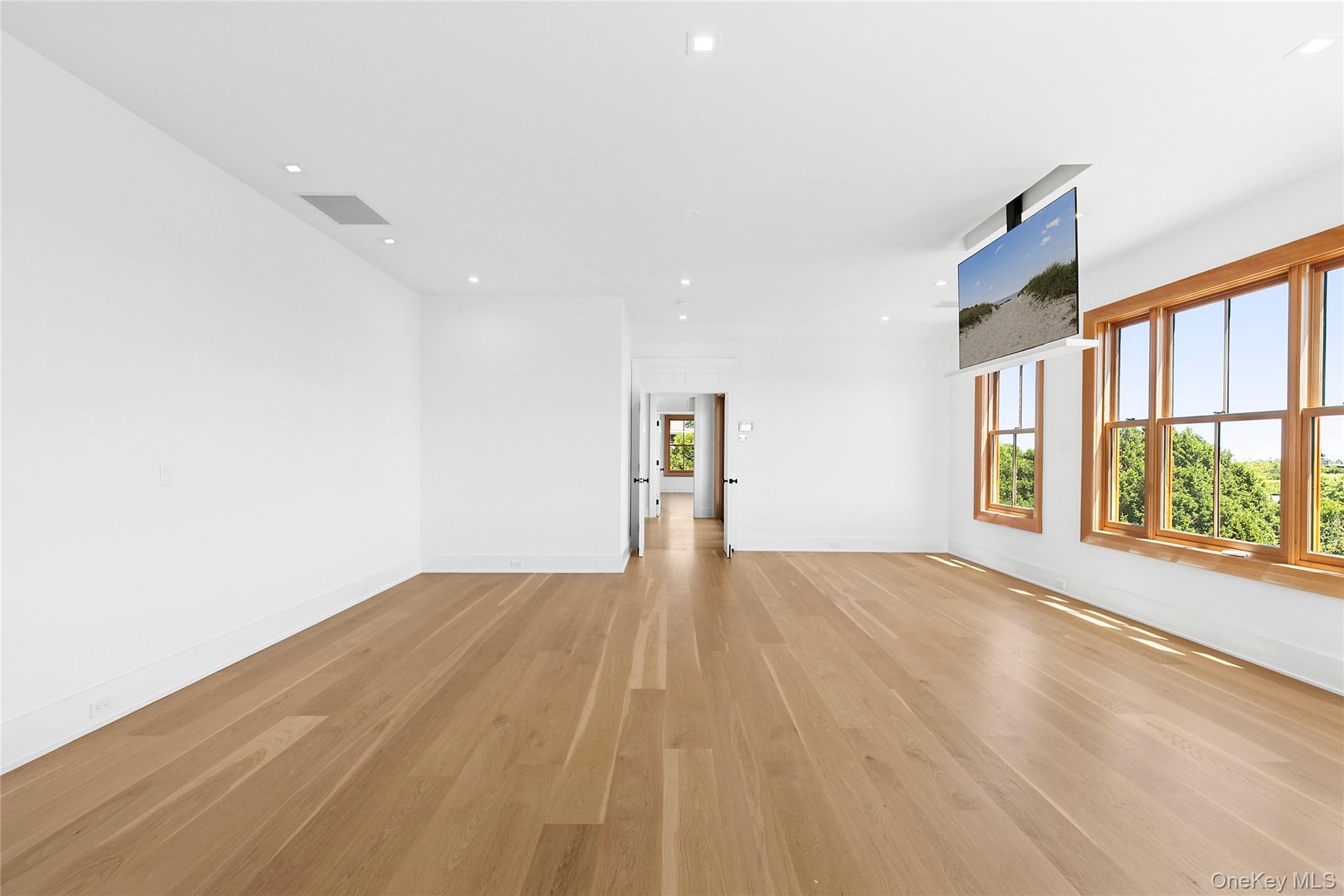 522 Wickapogue Road Southampton, NY 11968 - Photo 27 of 49 a view of an empty room with a window and wooden floor