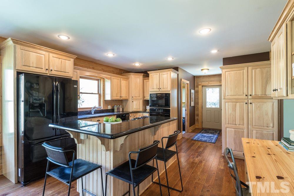 307 November Drive Durham, NC 27712 - Photo 14 of 30 a kitchen with stainless steel appliances granite countertop a refrigerator and a stove top oven with wooden floor