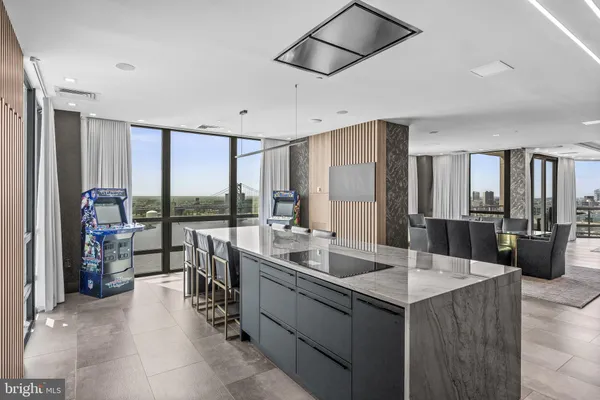 a living room with stainless steel appliances kitchen island granite countertop a refrigerator a sink a stove top oven and a dishwasher