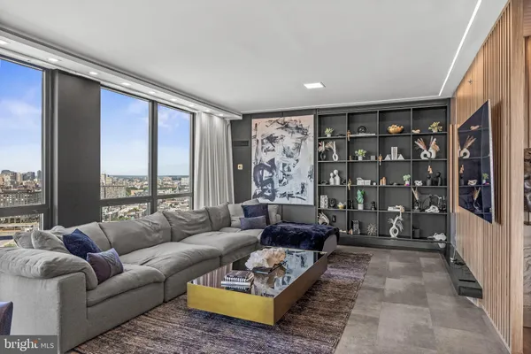 a living room with furniture a large window and a flat screen tv