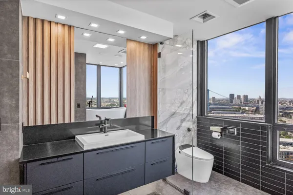 a bathroom with a sink a toilet a mirror and shower
