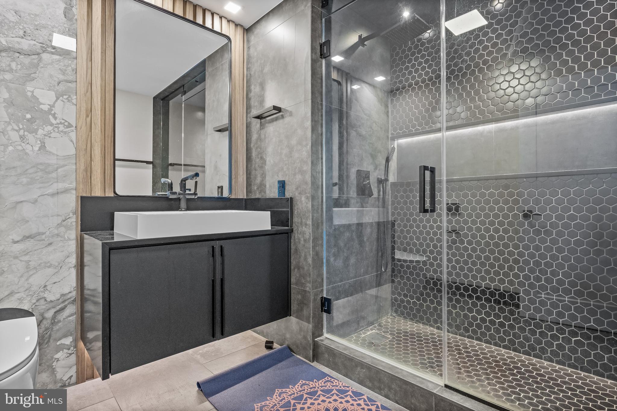 901 North Penn Street, Unit P24012 Philadelphia, PA 19123 - Photo 35 of 59 a bathroom with a sink a toilet a mirror and shower