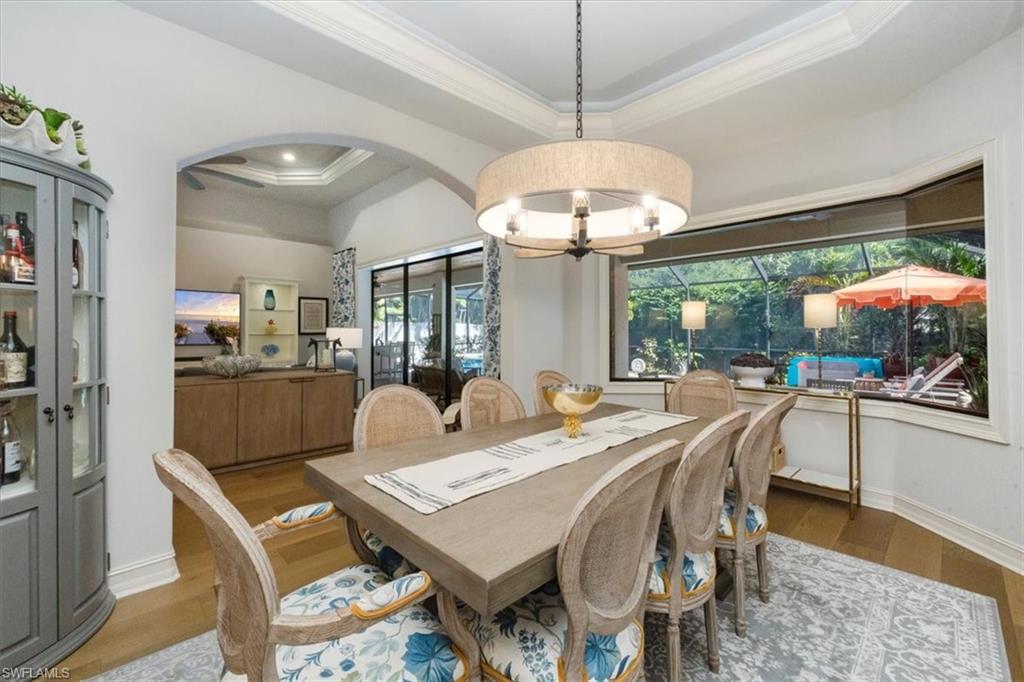 7263 Acorn Way Naples, FL 34119 - Photo 11 of 34 a view of a dining room with furniture wooden floor and chandelier