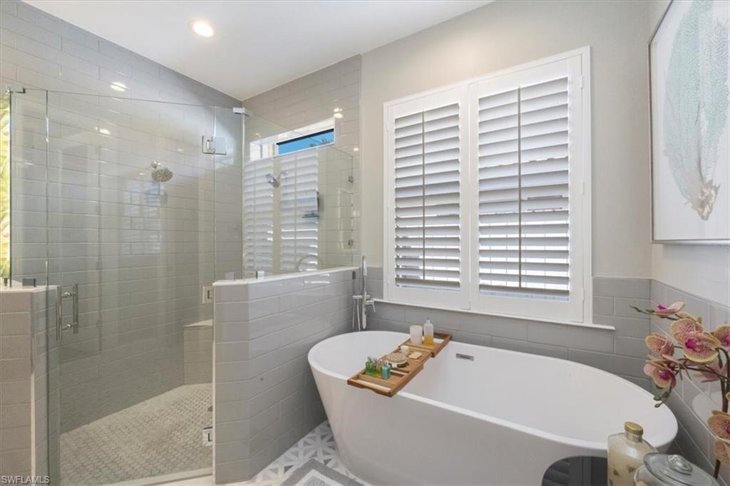 7263 Acorn Way Naples, FL 34119 - Photo 15 of 34 a bath tub sitting in a bathroom next to a window
