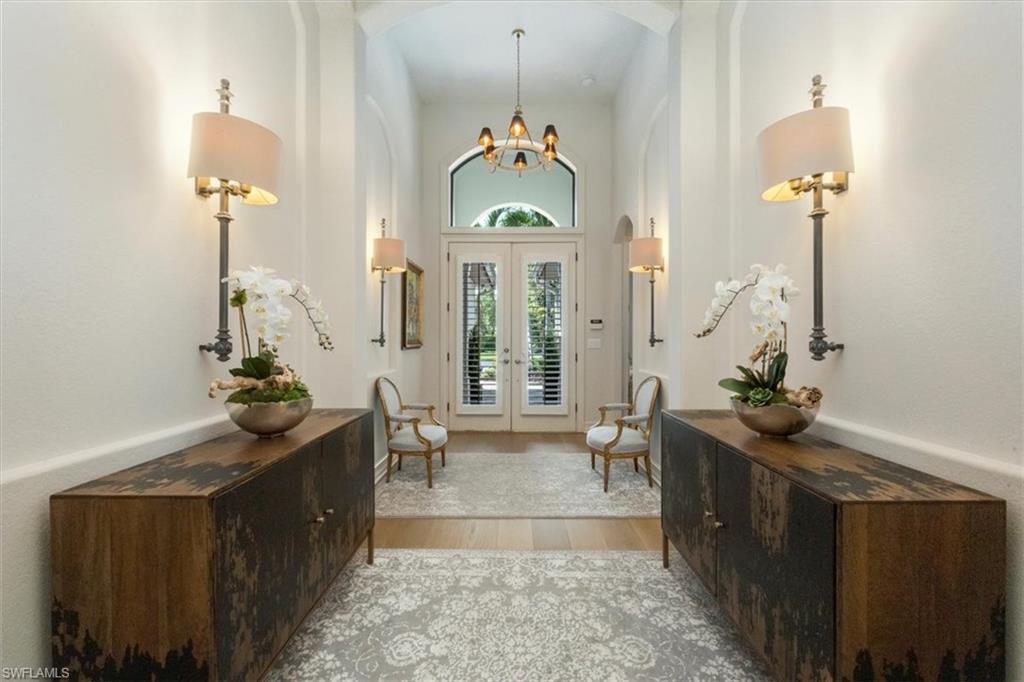 7263 Acorn Way Naples, FL 34119 - Photo 2 of 34 a living room with furniture and a chandelier