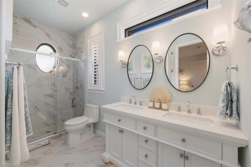 7263 Acorn Way Naples, FL 34119 - Photo 30 of 34 a bathroom with a double vanity sink mirror and toilet