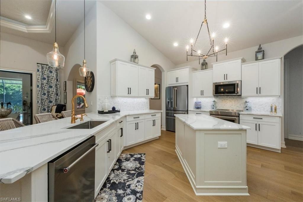 7263 Acorn Way Naples, FL 34119 - Photo 7 of 34 a large kitchen with cabinets and stainless steel appliances