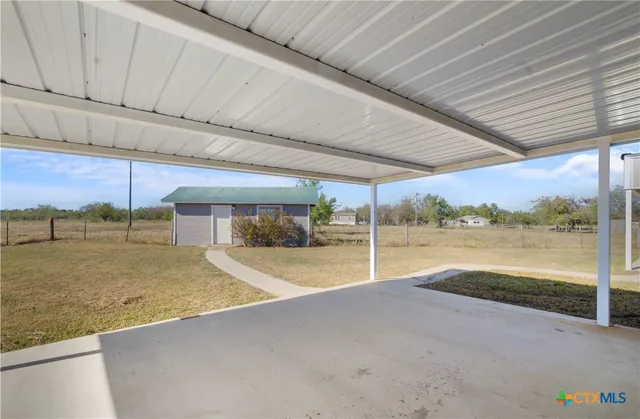 a view of an house with backyard and a tree
