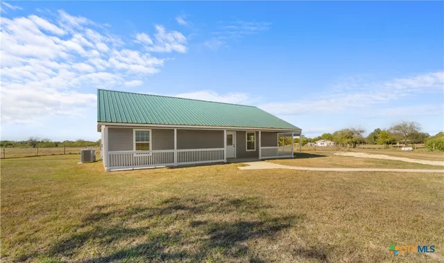 a view of house with yard and ocean view