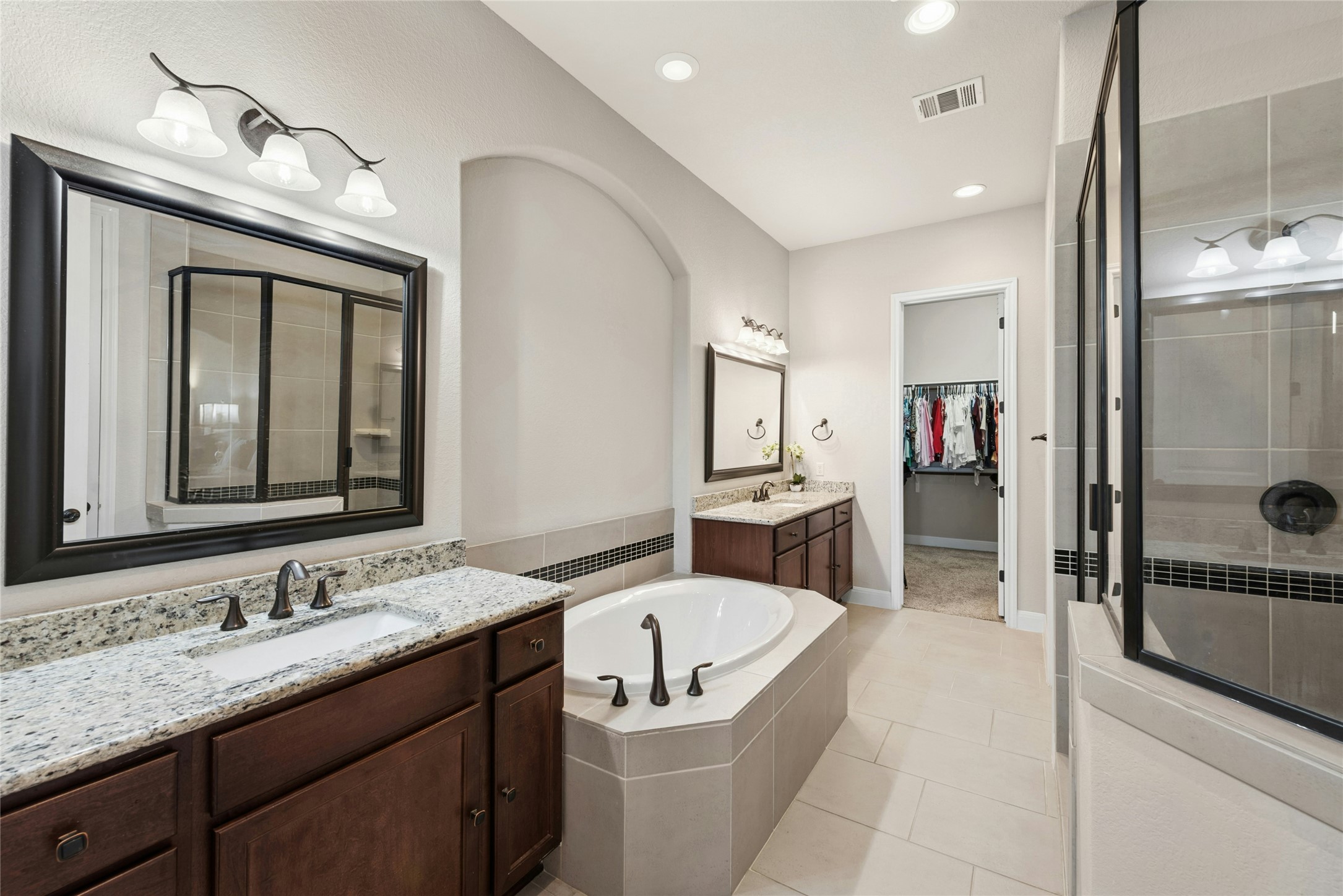 116 Evolutions Path Lakeway, TX 78738 - Photo 18 of 34 Full bath with a spacious closet, two vanities, light tile patterned floors, a bath, and a stall shower