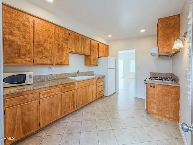 a kitchen with granite countertop a sink stove and cabinets