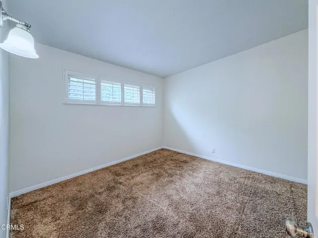 a view of a patio with a table and chairs under an umbrella