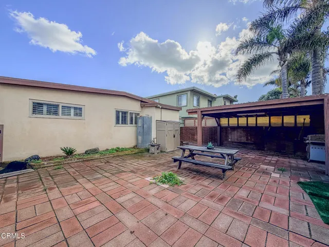 a view of a backyard with table and chairs and wooden fence