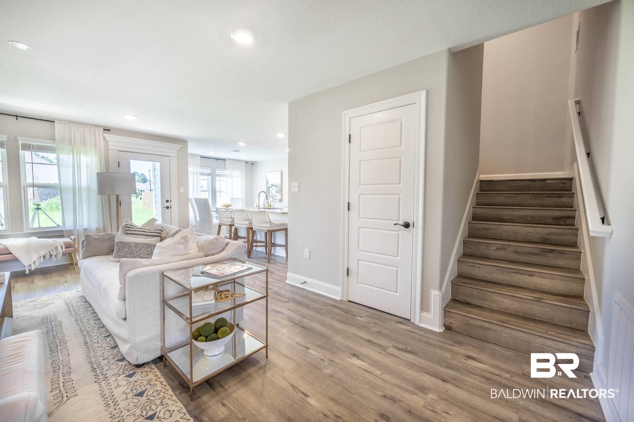 12918 Flanagan Street Elberta, AL 36530 - Photo 15 of 33 Wood-finish flooring throughout the main level, featuring a five-panel interior door and an open staircase with a painted handrail