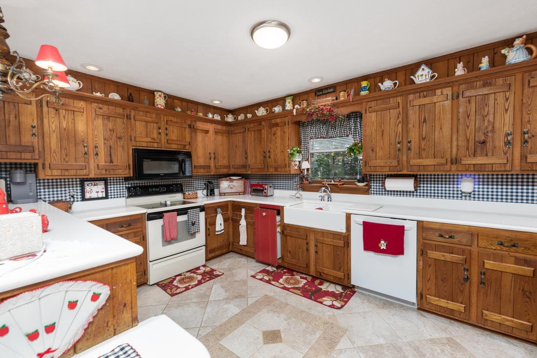 198 Baynes Road Waynesboro, VA 22980 - Photo 19 of 74 a kitchen with stainless steel appliances kitchen island granite countertop a sink dishwasher and a microwave with wooden cabinets