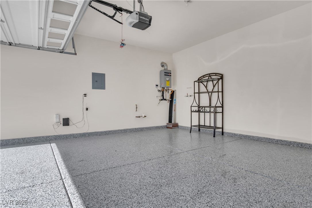 10073 Icicle Ridge Las Vegas, NV 89141 - Photo 9 of 23 Garage featuring a garage door opener, electric panel, and tankless water heater