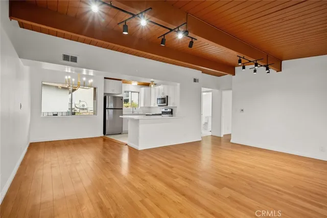 a view of empty room with wooden floor