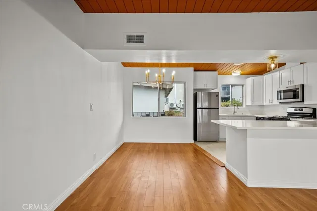 a view of a kitchen with wooden floor and electronic appliances