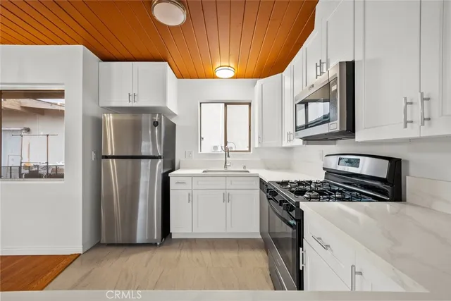 a kitchen with a refrigerator a stove a microwave and cabinets