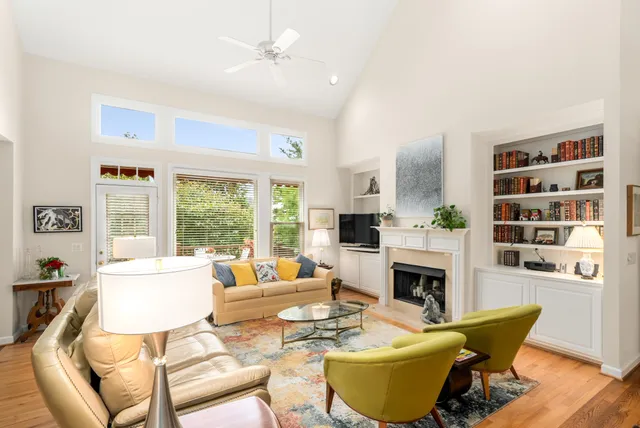 a living room with fireplace furniture and a large window