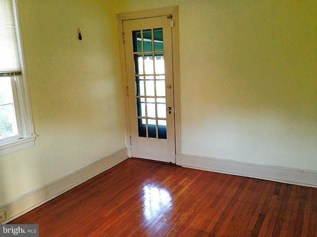 4419 Underwood Road Baltimore, MD 21218 - Photo 20 of 30 an empty room with wooden floor and windows