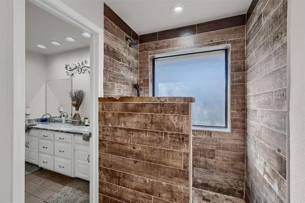 a bathroom with a granite countertop double vanity sink and a mirror
