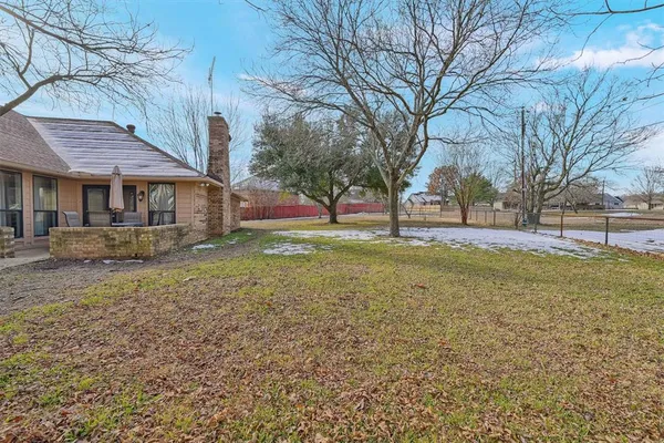 a view of a house with a big yard and large trees