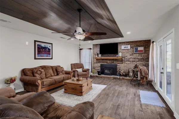 a living room with furniture a fireplace and a flat screen tv