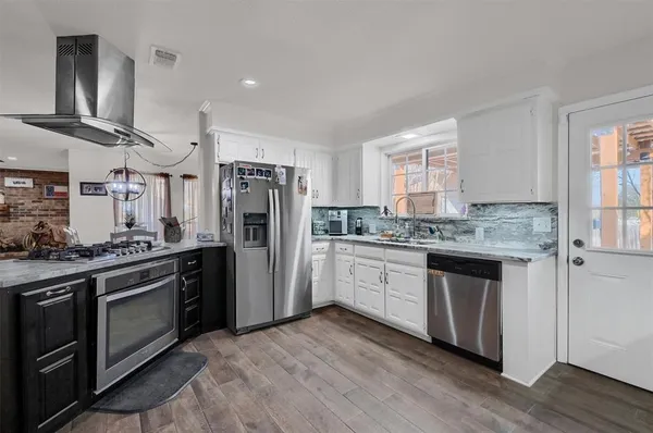 a kitchen with stainless steel appliances granite countertop a stove a sink and a refrigerator