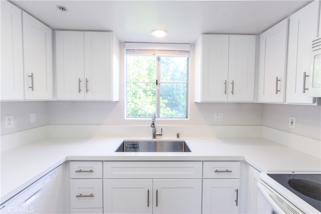 216 South Cross Creek Road, Unit K Orange, CA 92869 - Photo 1 of 1 a kitchen with white cabinets and a sink with dishwasher