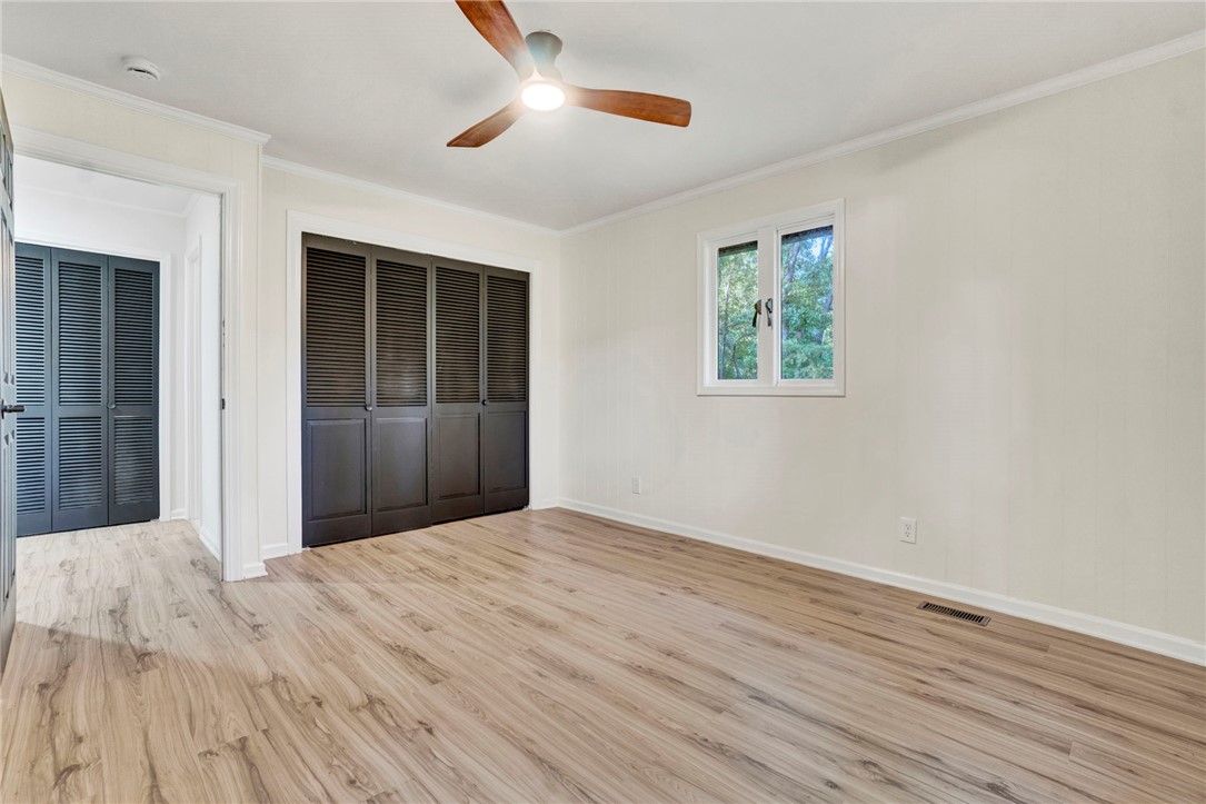 237 Earle Road Central, SC 29630 - Photo 19 of 24 A well-lit bedroom features sturdy laminate flooring and a ceiling fan for comfort.