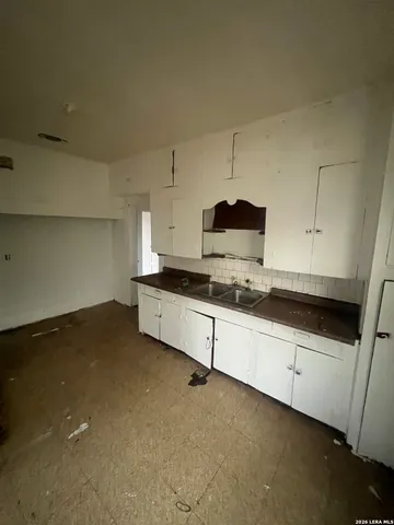 an empty room with windows and fireplace